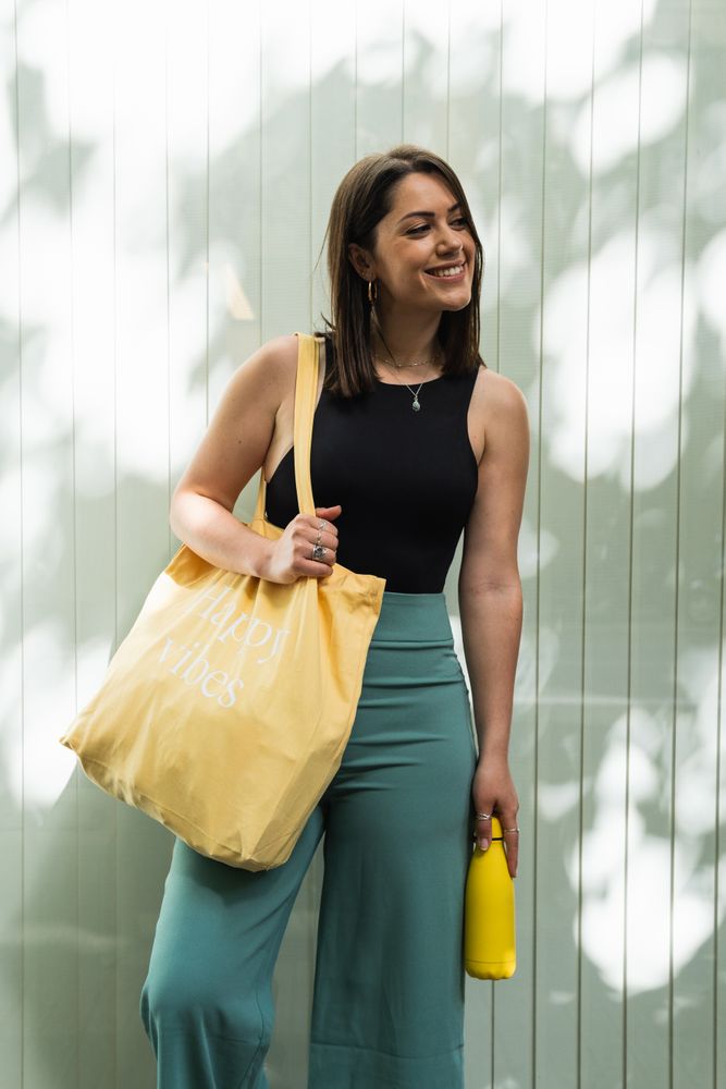 Happy woman with eco friendly bag in city