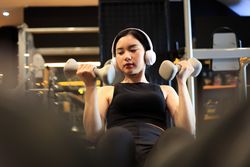 Young Female Training at the Gym Using Dumbbells