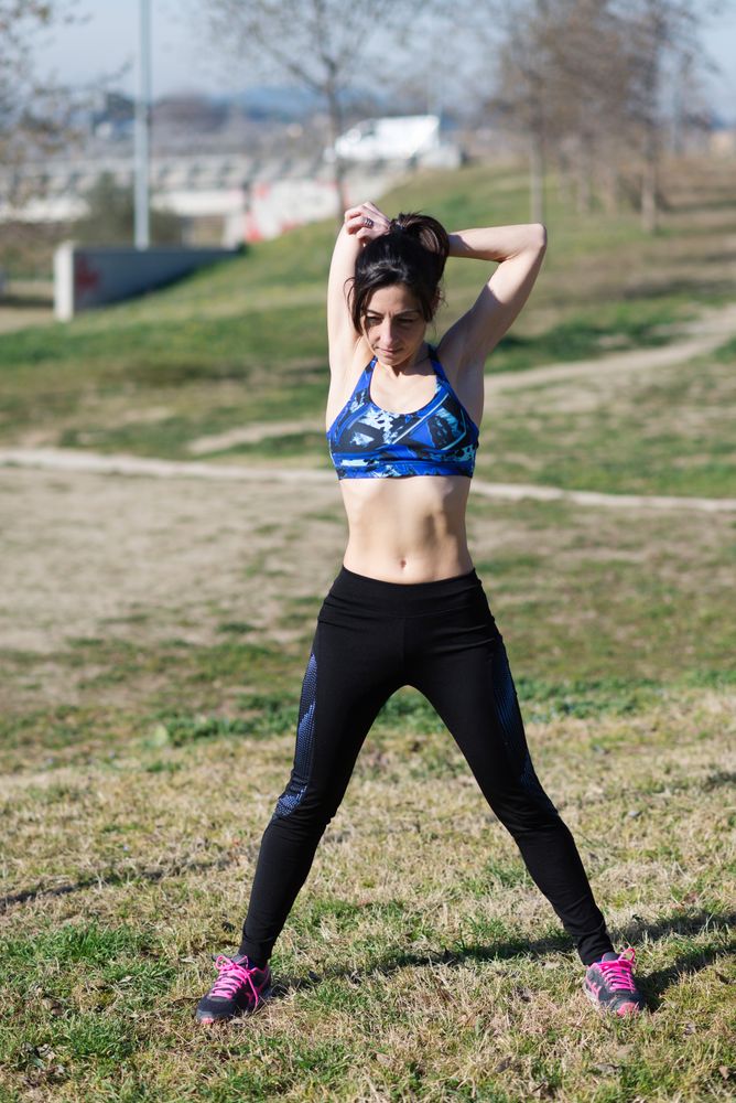 Woman stretching biceps in park