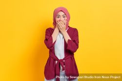 Surprised woman in red headscarf looking at camera with both hands over her mouth 4dwVl5