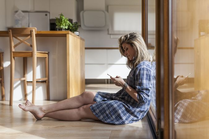 Woman at home leaning in a windows