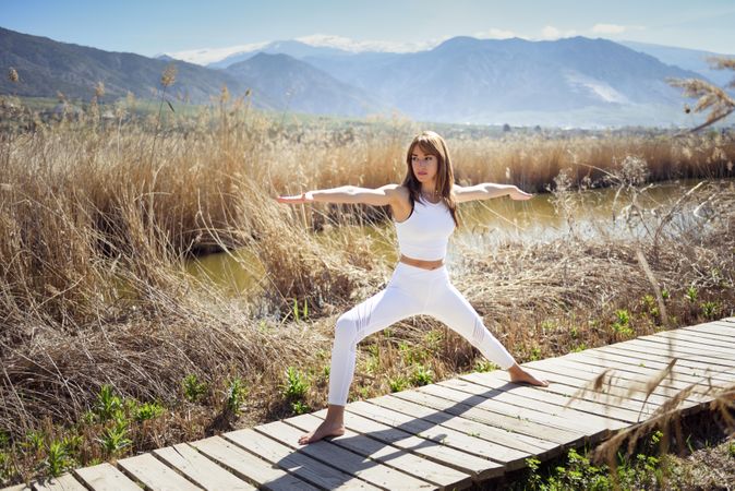Young woman doing yoga with mountains in the background