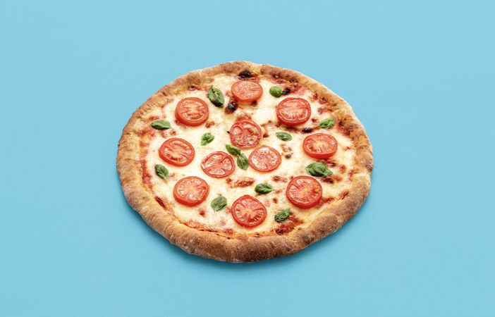 Homemade vegetarian pizza, isolated on a blue background