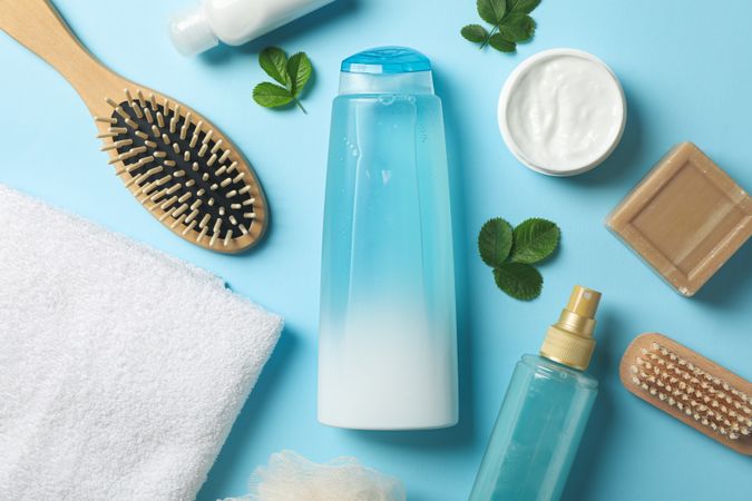 Composition of personal hygiene with bottles of cosmetics on blue background