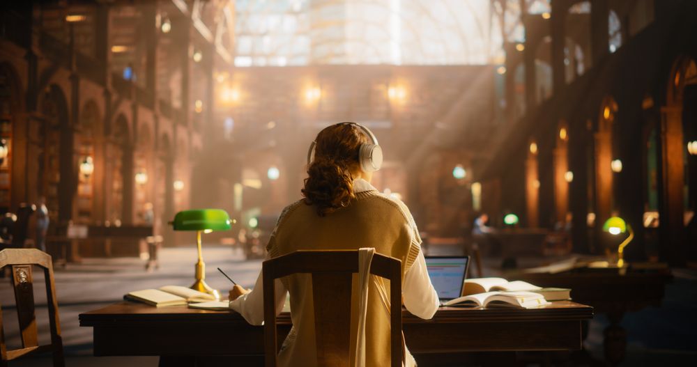 Serene Female Student Engaged in Online Learning in a Classical Library