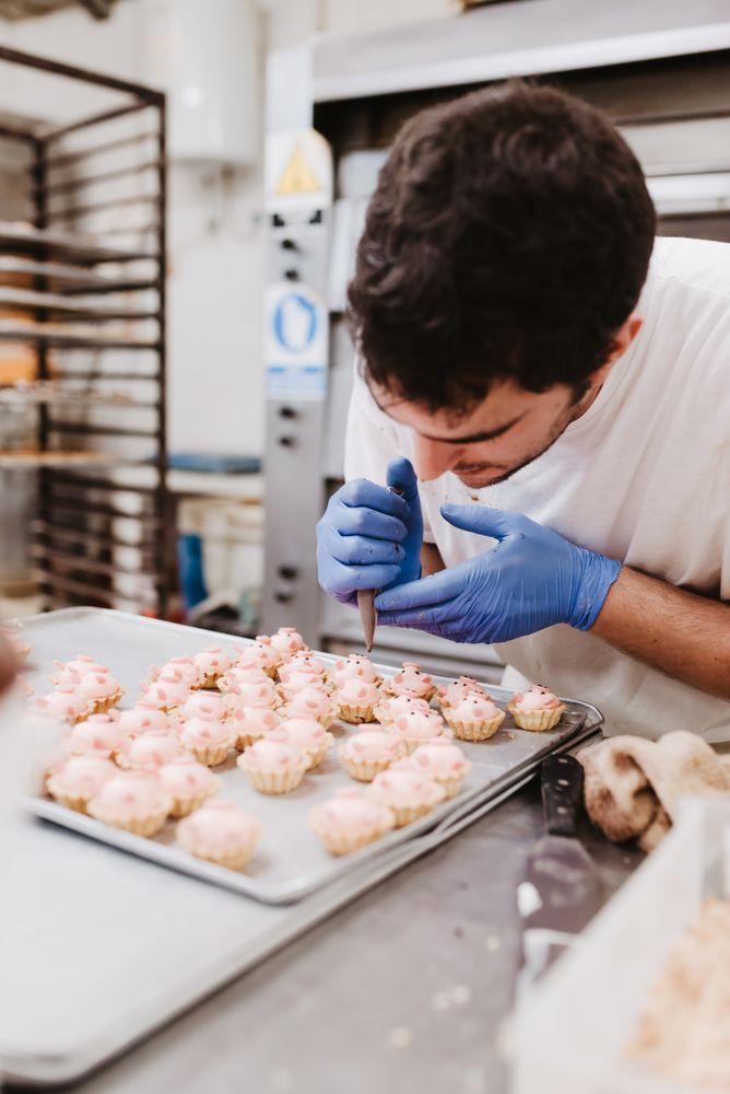 Crop baker squeezing dough on tray