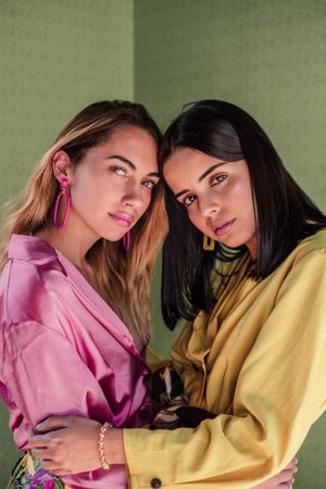 Young trendy women in bright clothes looking at camera