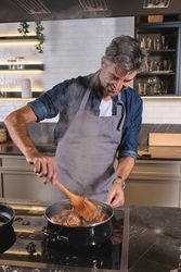 Man in apron cooking in kitchen