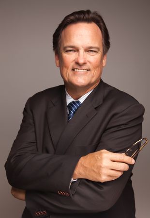 Professional Portrait of Smiling Businessman on Grey Background