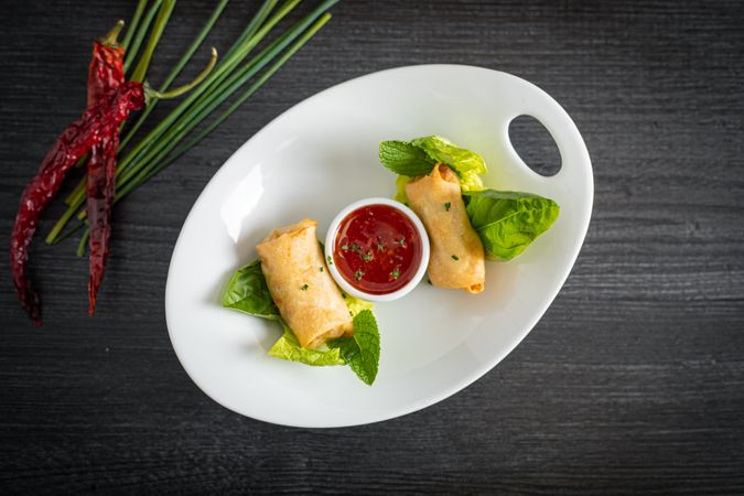Vietnamese rolls with sweet chili on glass plate