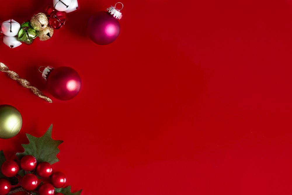Red Christmas background with Christmas decorations, holly and ornaments.