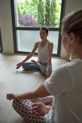 Females sitting in Padmasana pose while practicing yoga