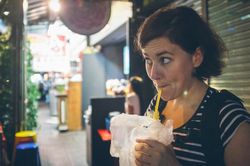 Woman drinking on city street