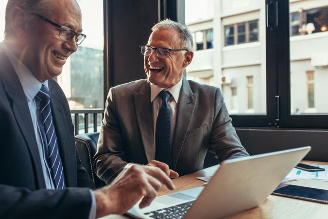 Two professional men laughing during work meeting