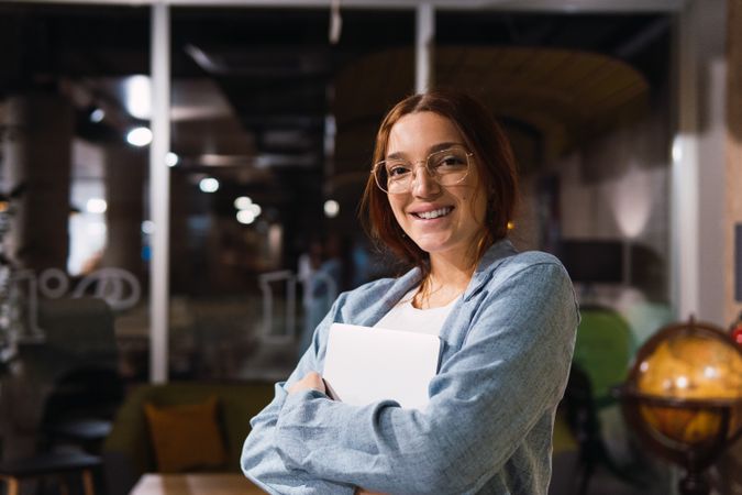 Happy female manager with laptop in workplace