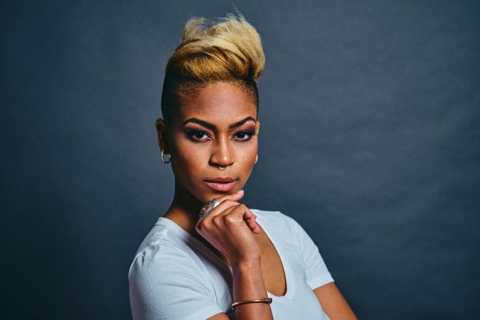 Picture of serious Black woman with short blonde hair with hand to her chin