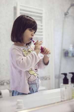 Girl brushing her teeth in bathroom