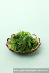 Bowl of Japanese seaweed salad on mint background 4ON9Z5