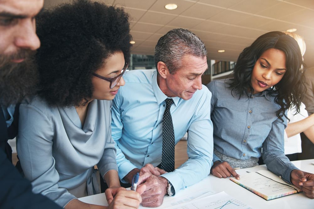 Multi-ethnic group of colleagues looking over documents at work