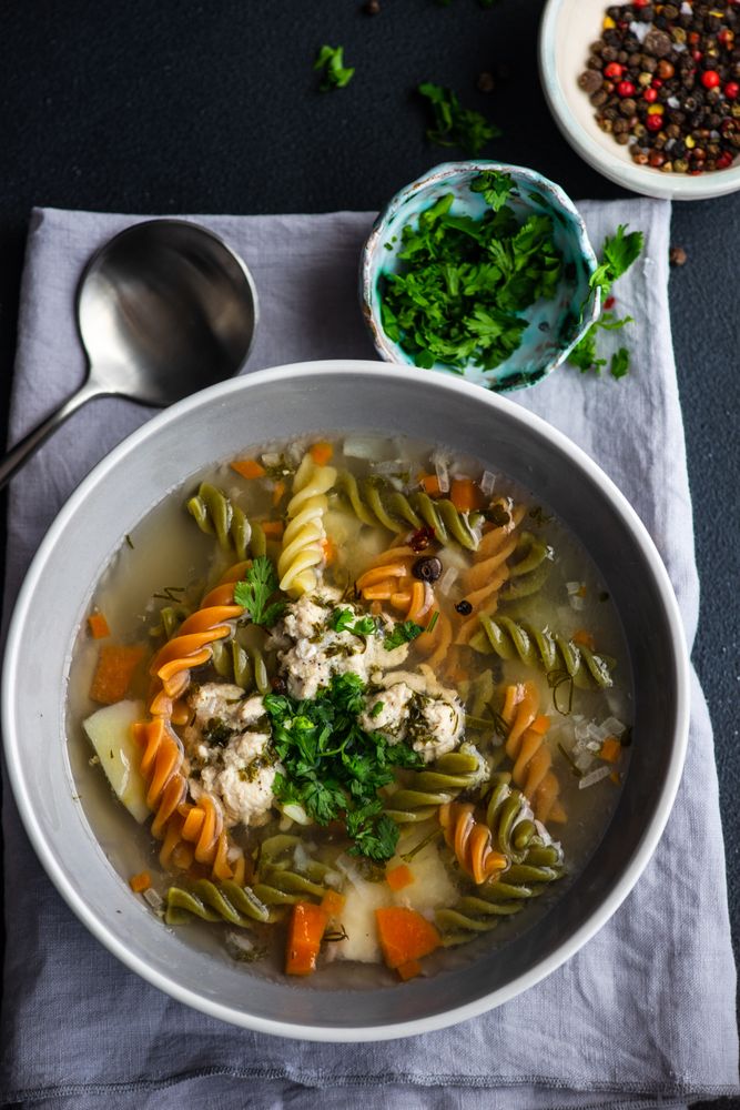Top view of healthy soup with spinach pasta and meat balls served on the table with copy space