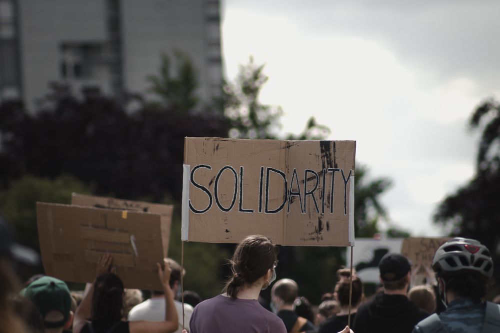 People holding banner with text "Solidarity" at BLM protest 