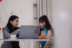 Collaborative Cafe, Two Women Working Together on a Laptop