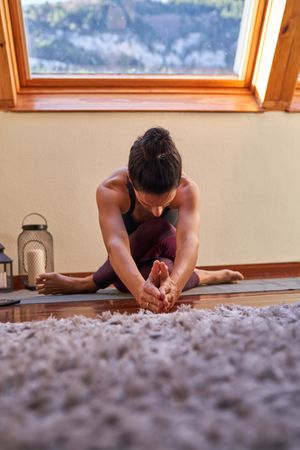 Unrecognizable woman stretching body at home