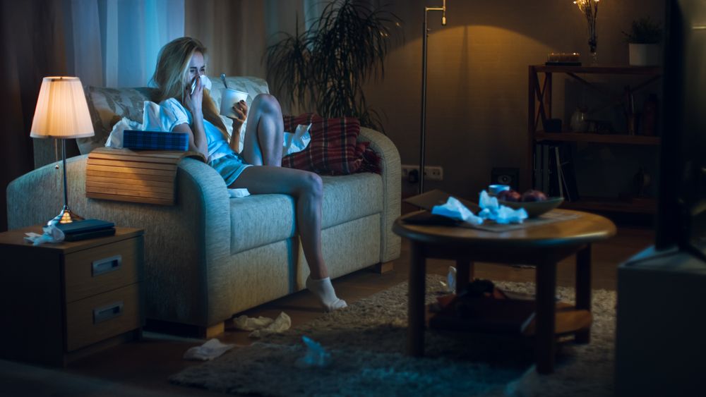 In the Evening Heartbroken Woman Sitting on a Sofa, Crying Eating Ice Cream