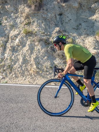 healthy man riding a bicycle on a mountain road in a sunny day