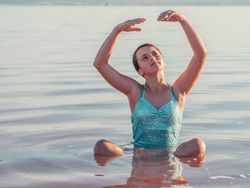 Teenage girl sitting in fresh water in sunny day