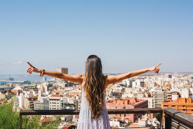 Woman on balcony looking at city views from above
