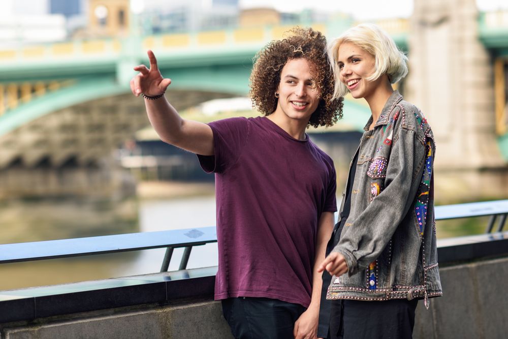 Man pointing in the distance with his girlfriend over river