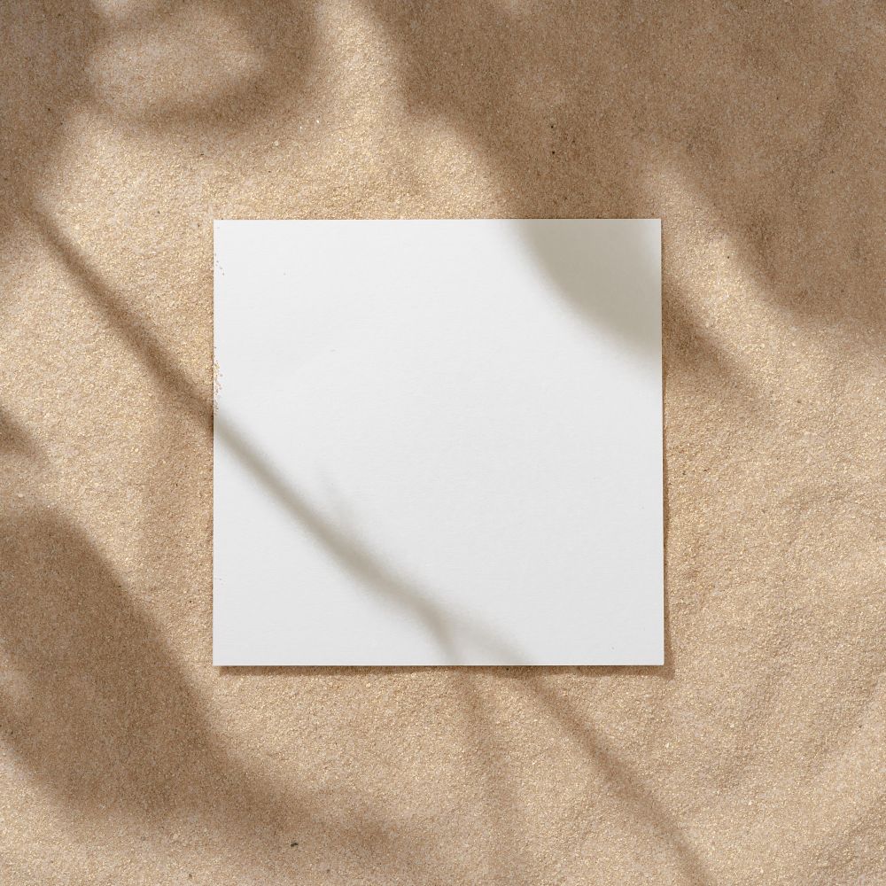Sand with palm leaf shadows and central square