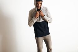 Smiling man holding onto hood in studio shoot