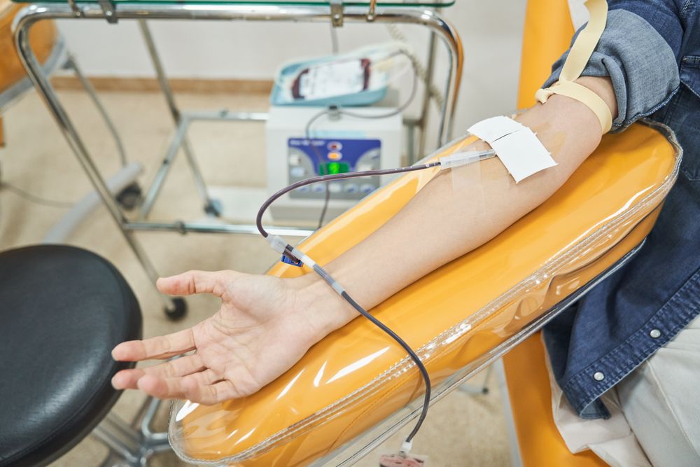 Unrecognizable female patient donating blood in hospital
