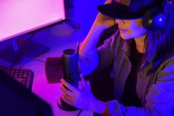 Woman with microphone and headphone working on a computer