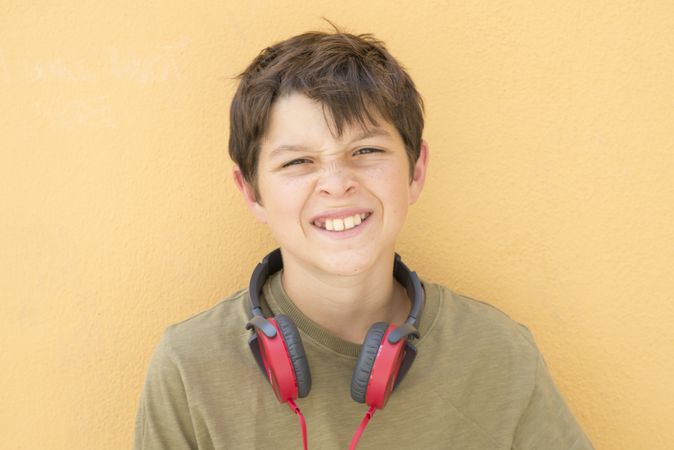 Smiling teen boy posing outdoors scrunching his nose