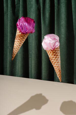 Waffle cones with pink fabric on green curtain background