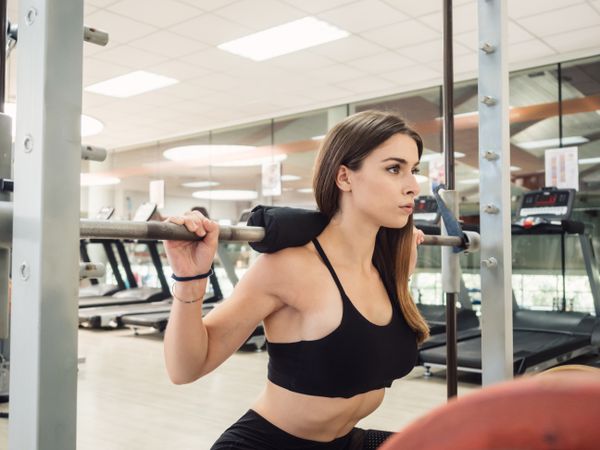 Young athlete squatting with barbell