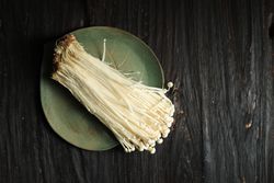 Enoki mushrooms on green plate