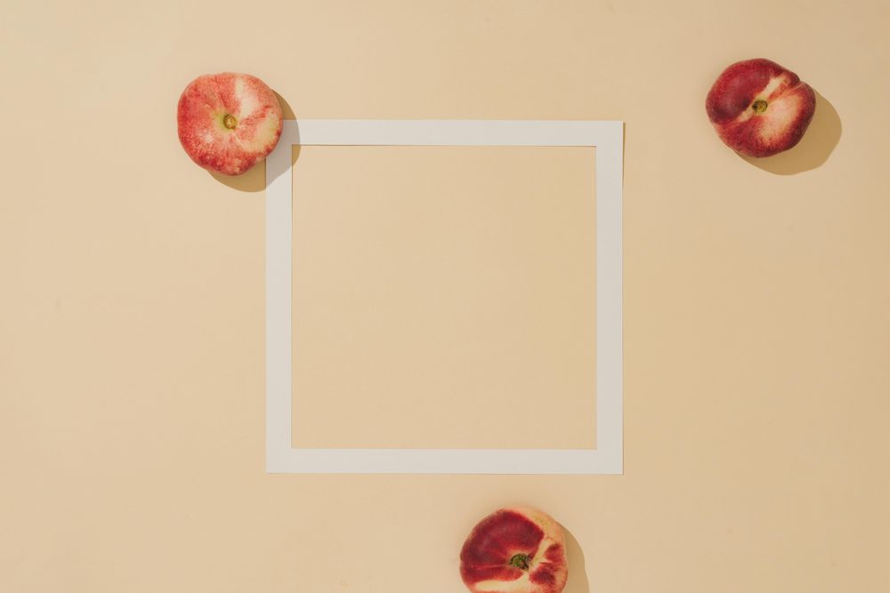 Minimal sunlit fruit composition with sand color background and sharp shadows