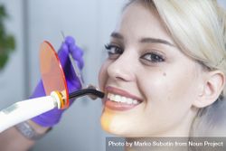 Woman smiling while having a dental procedure done bDmpQ0