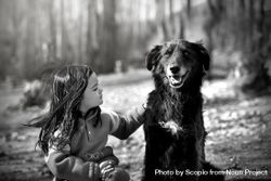 Grayscale photo of girl sitting beside dog outdoor bDAPK0