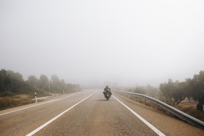 Motorcyclist riding into the fog