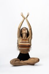 Spiritual woman with natural hair meditating with arms up in boho style