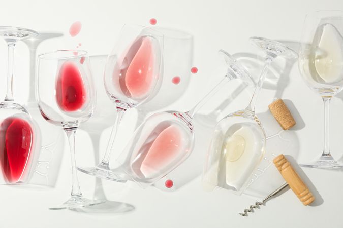 Flat lay composition. Corkscrew, glasses with different wine on blank background