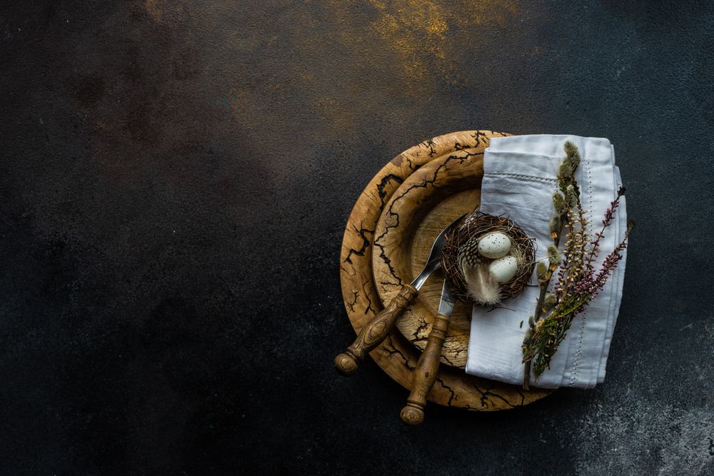 Easter spring card concept with top view of egg in small nest on rustic plate with space for text