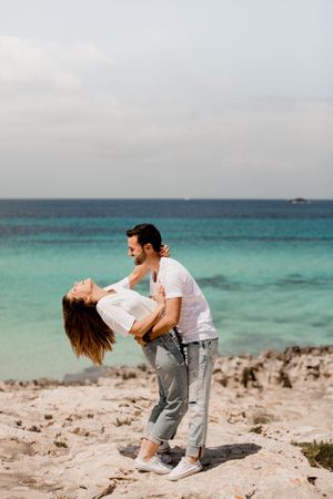 Laughing lovers hugging on beach