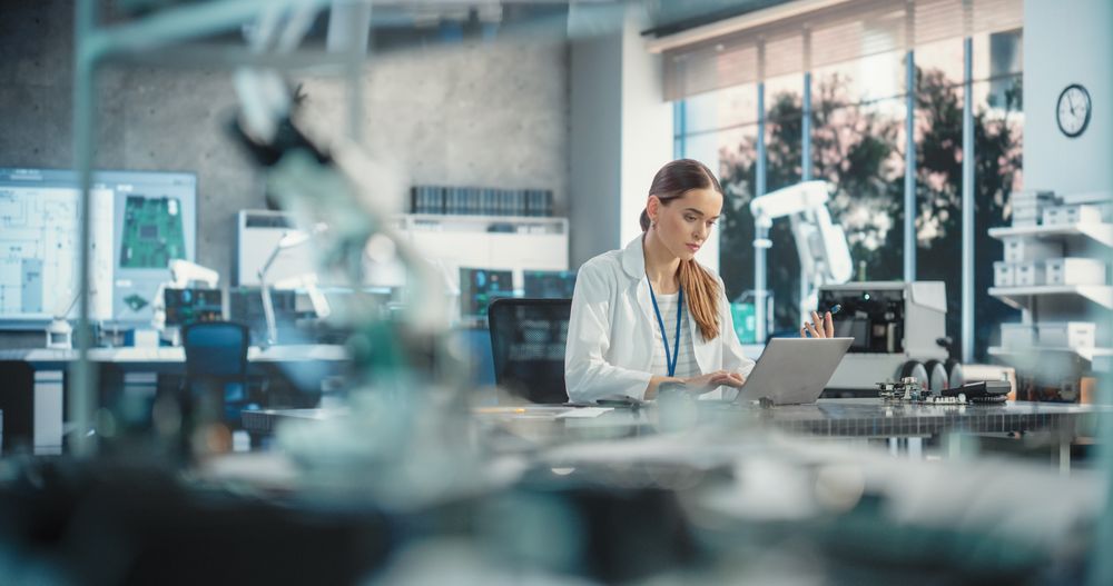 Portrait of Professional Female Scientist Working in Industrial Lab Using Laptop Computer.