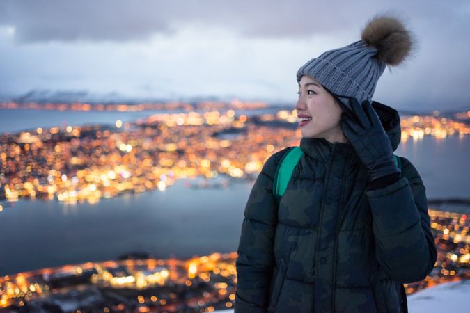 Joyful millennial woman enjoying view of night city